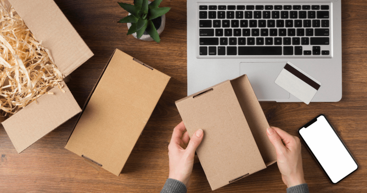 two hands holding software boxes with laptop and mobile